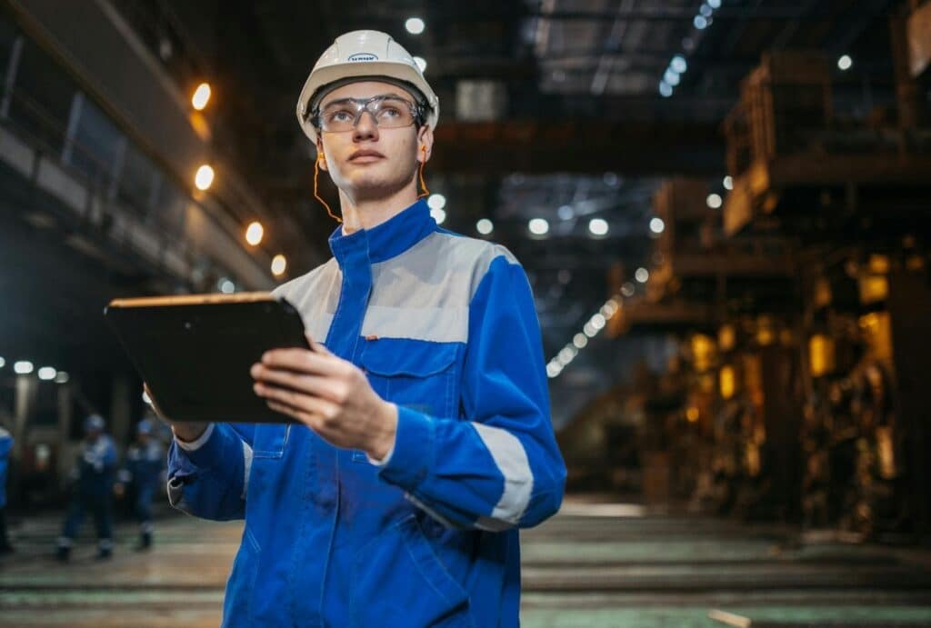 Cómo conseguir clientes para mi empresa industrial 2 Técnico industrial consultando herramientas digitales y automatizaciones basadas en IA para seleccionar proveedores y optimizar procesos.